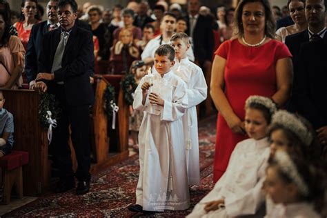 Fotografia krstného obradu s kňazom, rodičmi a krstnými rodičmi pri krstiteľnici