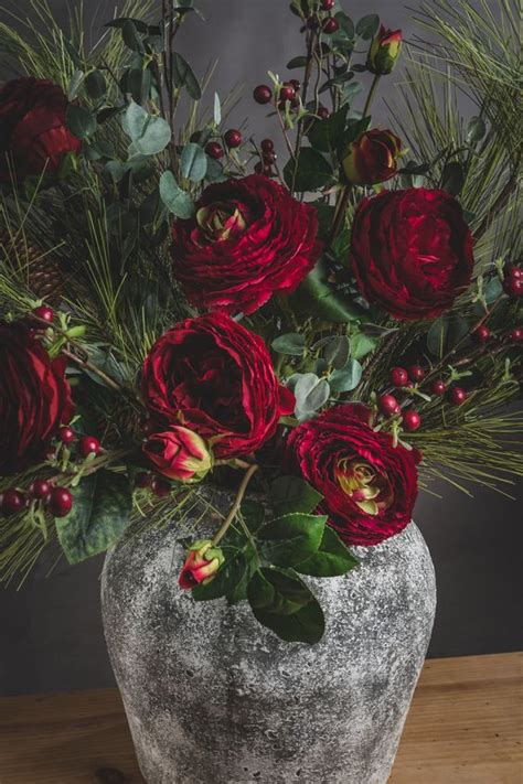 Detailný záber na bielu vianočnú ružu v keramickom kvetináči ako súčasť sviatočnej výzdoby