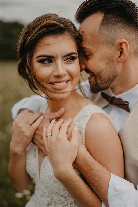 Pár sa usmieva a komunikuje so svadobným fotografom počas prípravnej schôdzky, v pozadí fotografie svadobných albumov.