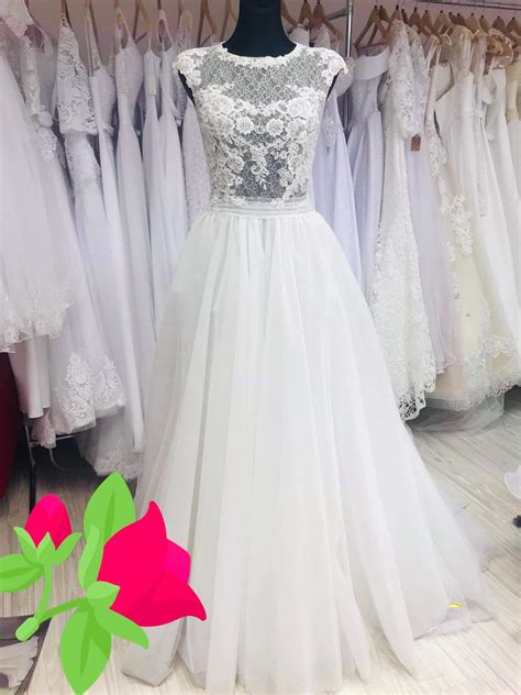 Nevesta si oblieka svadobné šaty v elegantnej, svetlej hotelovej izbe.