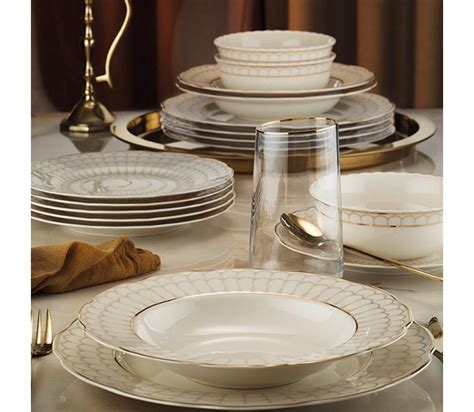 Kombinácia elegantných tanierov so zlatými detailmi a prírodných prvkov.