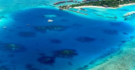 Letecký pohľad na tropický luxusný rezort na Bali s bazénmi a palmami pri západe slnka