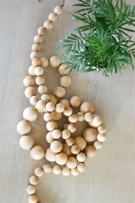 Vianočná reťaz z drevených guľôčok navlečených na prírodnom povrázku.