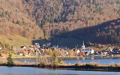 Ilustrácia zimnej dedinky s figúrkami a stromčekmi.