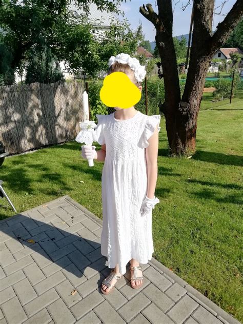 Tematické foto: usmievajúce sa dievčatko v krásnych bielych šatách na prvom svätom prijímaní