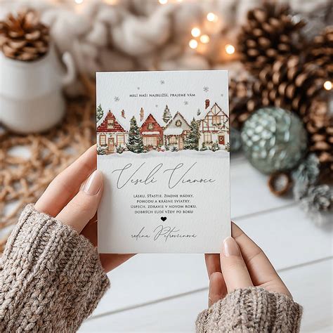 Ilustrácia zobrazujúca vianočnú dedinu so zasneženými domami a stromčekmi