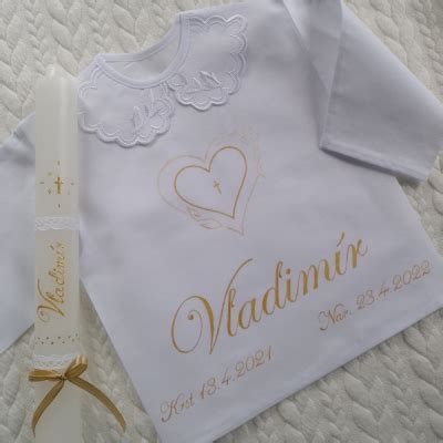 Súprava krstnej košieľky a zdobenej sviečky s rovnakým motívom výšivky.