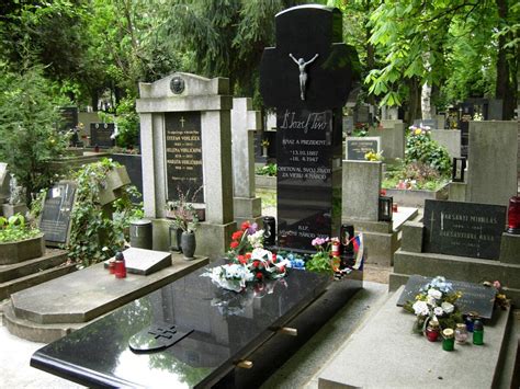 Slovenská rodina navštevujúca hrob svojich predkov na cintoríne počas Sviatku všetkých svätých.