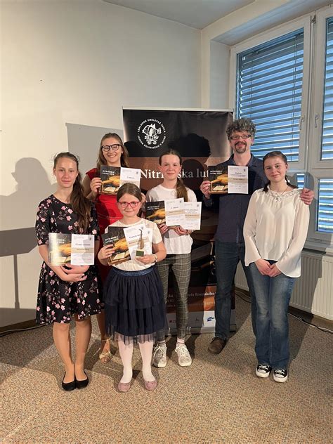 Skupina študentov s učiteľom na súťaži, znázorňujúca spoluprácu a nadšenie