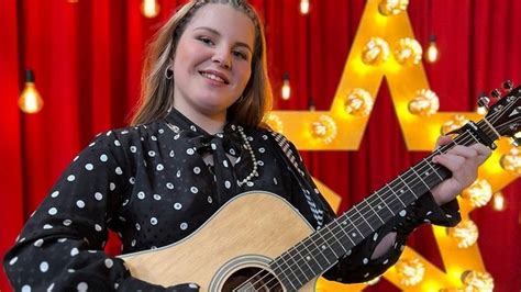 Dieťa v kostýme rockovej hviezdy s papierovou gitarou a mikrofónom, plné energie