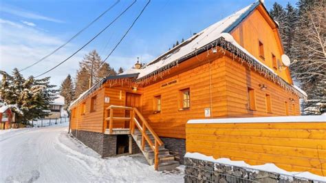 Drevená chata na Donovaloch v zime, s vírivkou pred chatou
