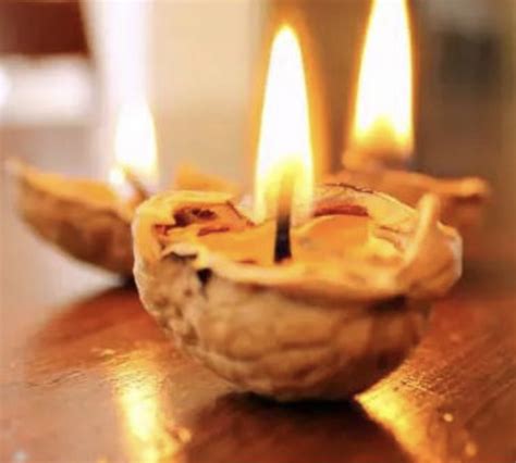 Detailný záber na zapálené lodičky zo škrupín vlašských orechov plávajúce v keramickej miske s vodou