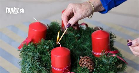 Tematické foto: Ruky zapaľujúce sviečku na adventnom venci