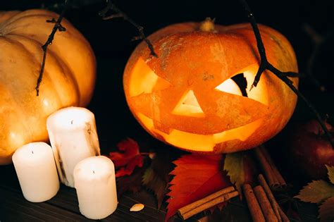 Tematické halloweenske dekorácie pre dospelých, vrátane vyrezávaných tekvíc, umelých pavučín a tlmeného osvetlenia