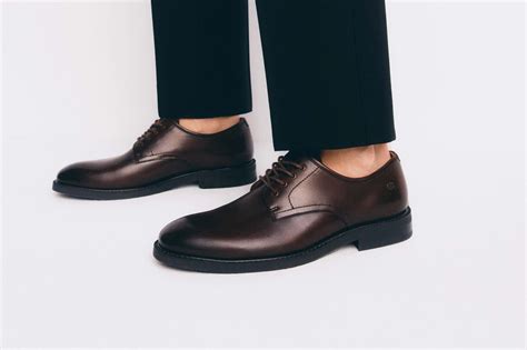 Detail pánskych hodiniek a elegantných topánok