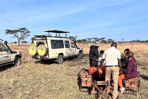 Pár v safari džípe pozorujúci divokú zver v Tanzánii