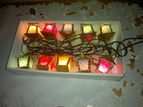 Koláž rôznych metód skladovania vianočných svetielok: na kartóne, vo forme osmičky, na vešiaku, vertikálne.