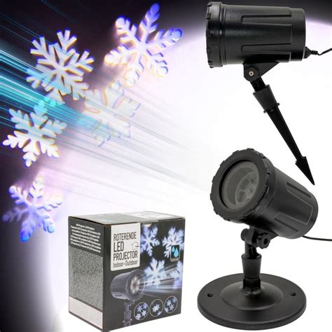 Vianočný projektor premietajúci snehové vločky na stenu obývačky