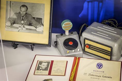 Tematická fotografia: Rečník pri mikrofóne pred odhalenou sochou/pamätníkom s publikom v pozadí