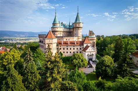Zámok alebo kaštieľ na Slovensku, s pár v svadobnom oblečení v popredí