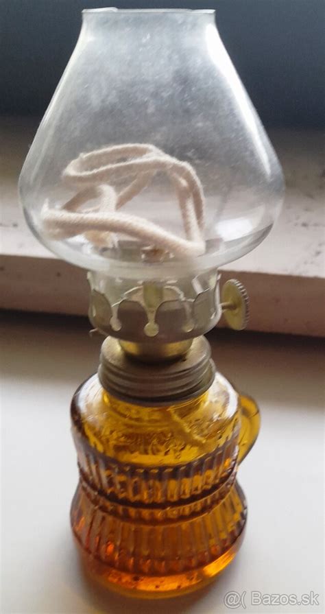 Fotografia ruky plniacej petrolejovú lampu pomocou lievika
