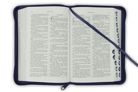 Tematické foto: Otvorená Biblia na stole so sviečkou a vianočnými prvkami