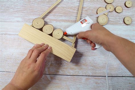 Konštrukcia dreveného stromčeka z tyčiek a drevených koliesok, pripravená na ďalšie zdobenie