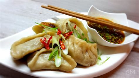fotografia tradičnej čínskej rodinnej večere s typickými pokrmami, ako sú knedličky jiaozi a ryba