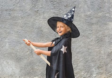 Dieťa v upírskom kostýme s umelými zubami a plášťom