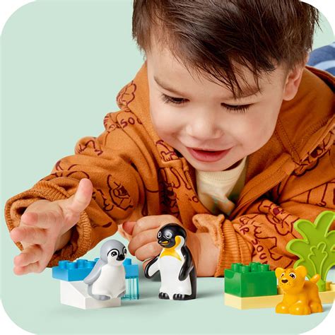 Dievčatko stavia vežu z farebných LEGO Duplo kociek s motívmi zvierat