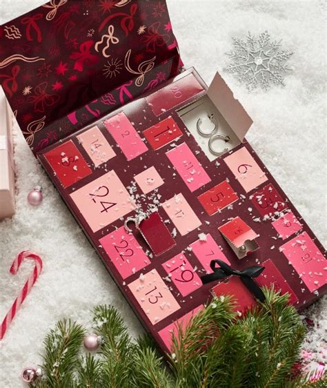 Tematická fotografia rôznych otvorených kozmetických adventných kalendárov s produktmi a vianočnou výzdobou