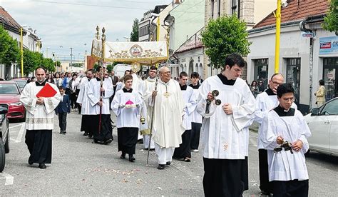 Záber na veriacich kráčajúcich v procesii ulicami obce s krížom v rukách