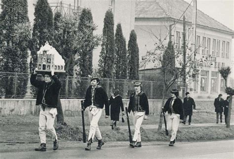 Betlehemci kráčajúci po hlavnej ceste popred budovu fary v Detve, r. 1980