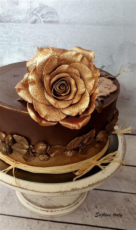 Detail torty s precíznymi cukrovými kvetmi a čokoládovými prvkami