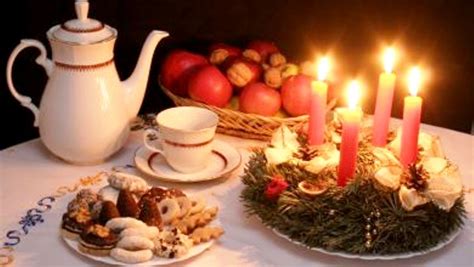 Rodina pri štedrovečernom stole s horiacimi sviečkami