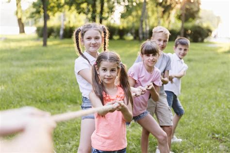deti a dospelí hrajúci preťahovanie lanom na záhrade