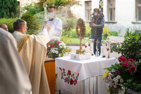 Fotografia tradičnej eucharistickej procesie s kňazom nesúcim monštranciu pod baldachýnom