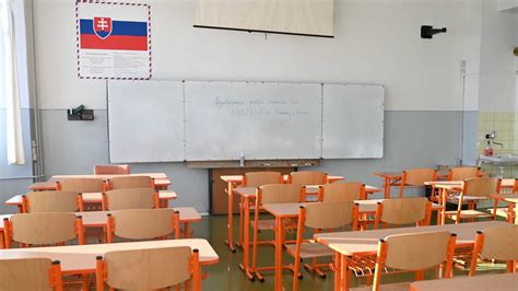 Tematické foto učiteľa, ktorý sa usmieva na skupinu žiakov, v pozadí školská trieda