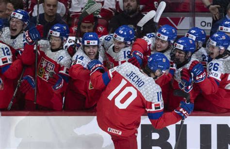 Hokejový hráč s rozpaženými rukami oslavuje strelený gól, publikum v pozadí buráca