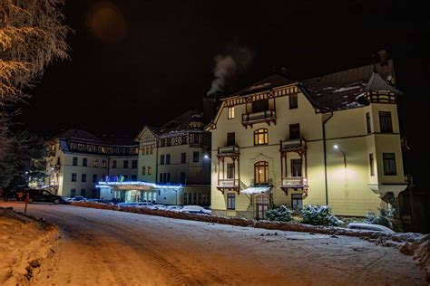 fotografia Grand hotela Starý Smokovec v obklopení hôr, s elegantne oblečenými hosťami prichádzajúcimi na podujatie
