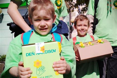 Tematické foto: dobrovoľníci s pokladničkami a žltými narcismi v uliciach mesta