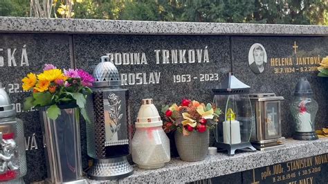 Rodina na cintoríne zapaľuje sviečky na hrobe
