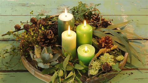 Detailný záber na adventný veniec ozdobený prírodnými materiálmi ako sú šišky, bobule a vetvičky