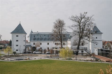Záber na osvetlený historický kaštieľ v malebnej prírode južného Slovenska počas jarného večera