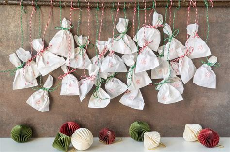 Adventný kalendár z papierových vrecúšok zavesený na konári