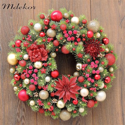 Tradičný vianočný veniec v červených tónoch s ihličím, bobuľami a šiškami