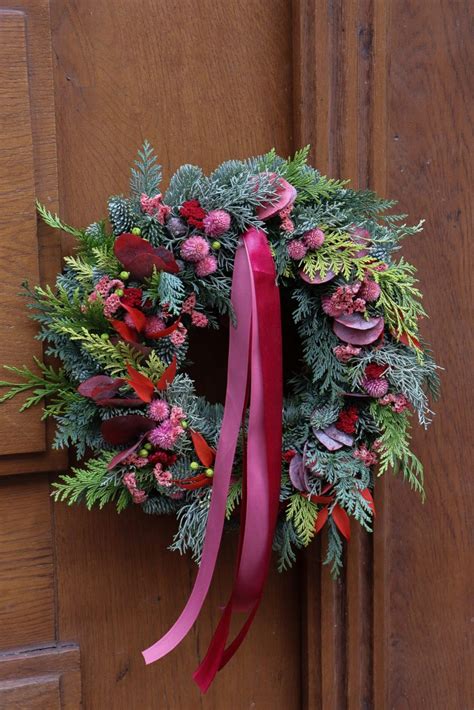 Minimalistický vianočný veniec z jedle, červených šípok a modrých kvetov