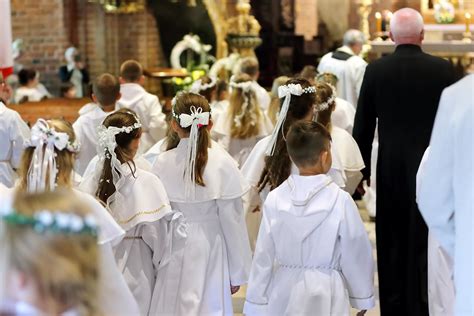 Záber na prvoprijímajúce deti v slávnostnom oblečení pred oltárom počas svätej omše