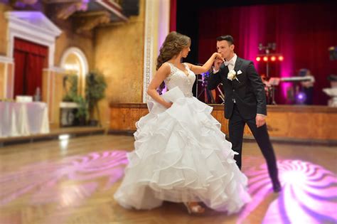 Svadobný pár tancujúci svoj prvý tanec v romantickom osvetlení sály