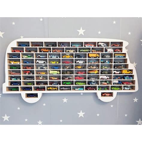 Ilustrácia adventného kalendára s otvorenými okienkami, kde sú viditeľné malé autíčka a iné hračky.